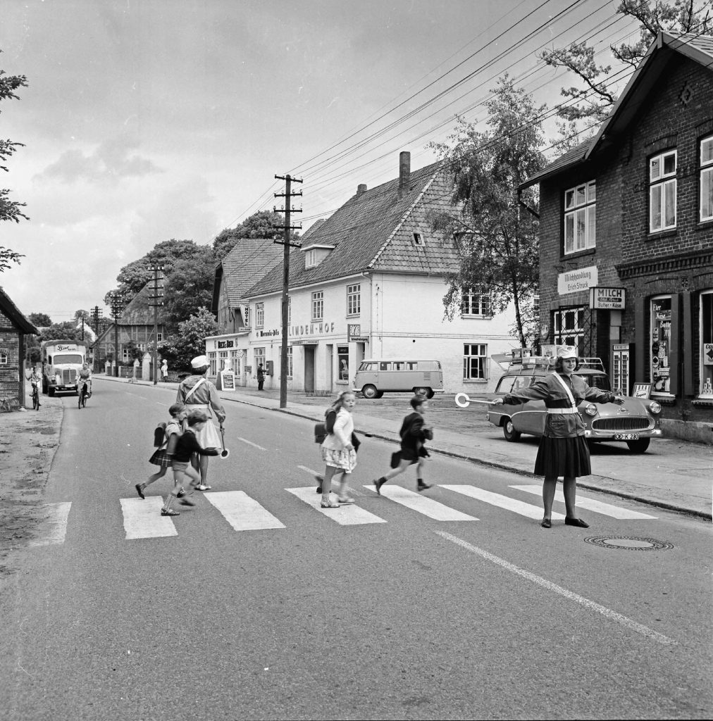 Bargteheide: Hamburger Straße / B 75: Fußgängerüberweg: Schülerlotsen geleiten Schulkinder über Zebrastreifen: Bildmitte Gaststätte Lindenhof, 1963
